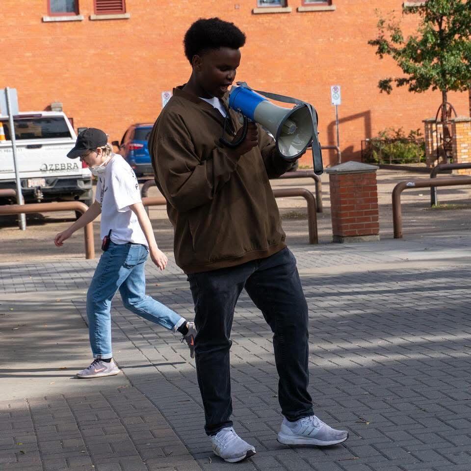 Haruun Ali speaking through a megaphone in Edmonton